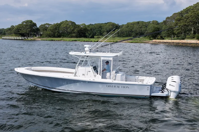 Slide: The Image of 2019 Regulator 34SS boat cruising on a scenic lake with lush green shoreline. - 9