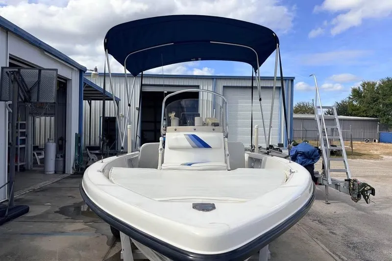 Slide: The Image of 2003 Sea Chaser 1900 CC boat with blue canopy in a boatyard. - 7