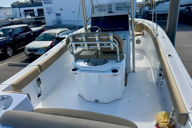 Slide: The Image of 2017 Sportsman Heritage 251 Center Console boat interior with seating and console, parked outdoors. - 12