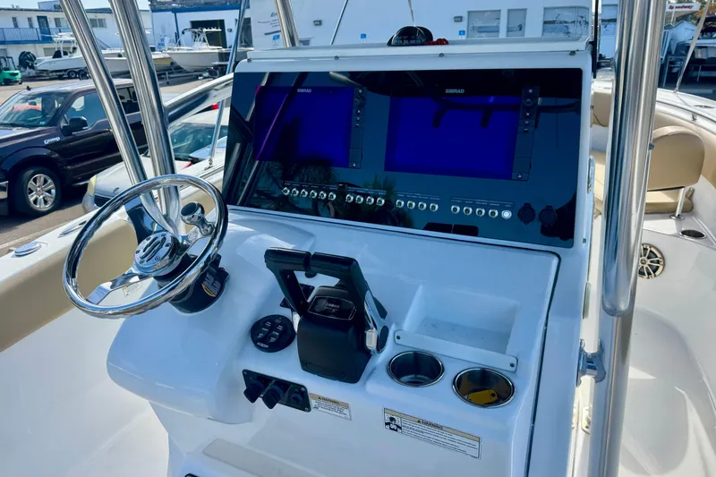 Slide: The Image of 2017 Sportsman Heritage 251 Center Console boat dashboard with steering wheel and navigation screens. - 20