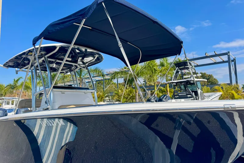 Slide: The Image of 2017 Sportsman Heritage 251 Center Console boat with canopy, docked under clear blue sky. - 9