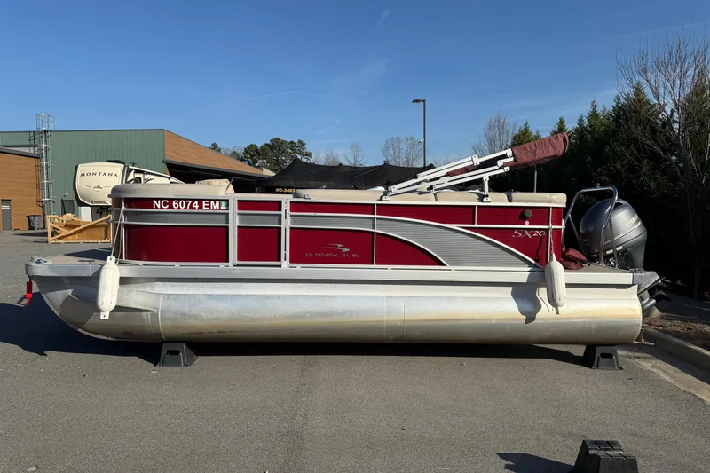 The Image of 2019 Bennington SX 20 SLX pontoon boat with red and silver design, parked outdoors. - 0