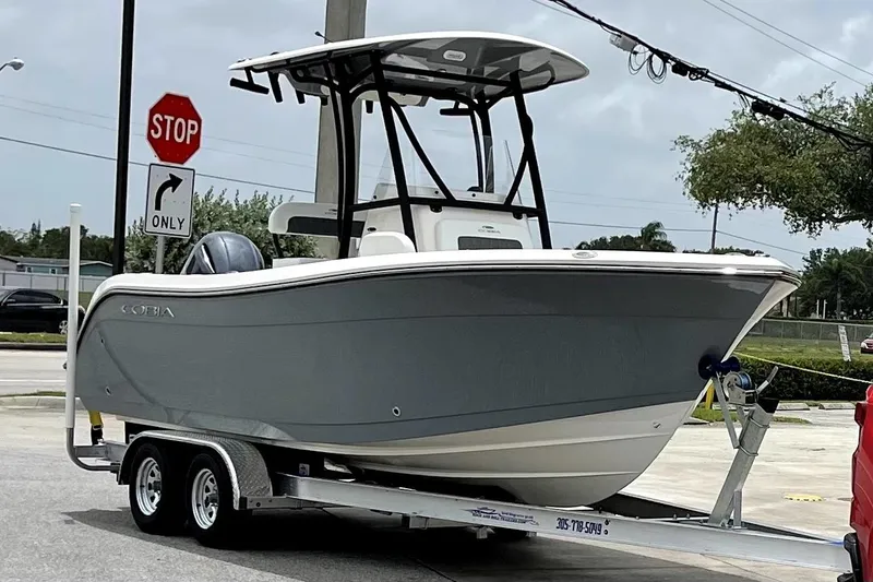 The Image of 2022 Cobia 220 Center Console boat on trailer in parking lot, sunny day. - 0