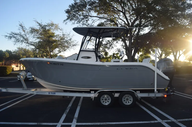 Slide: The Image of 2022 Cobia 220 Center Console boat on trailer in sunny parking lot. - 11