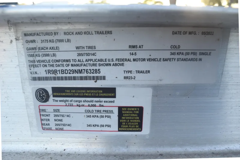 Slide: The Image of Label on a 2022 Cobia 220 Center Console trailer, detailing weight and tire specifications. - 16