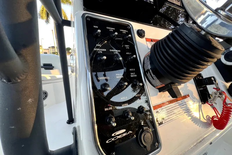 Slide: The Image of 2022 Cobia 220 Center Console boat dashboard with control panel and steering wheel. - 19