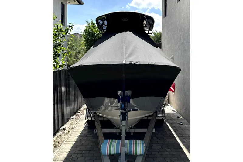 Slide: The Image of 2022 Cobia 220 Center Console boat on trailer in sunny parking lot. - 2