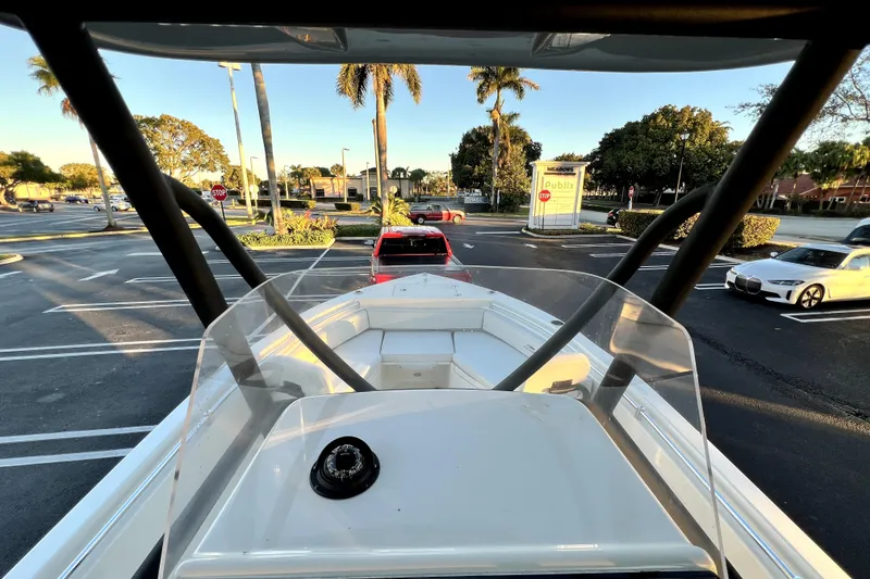 Slide: The Image of 2022 Cobia 220 Center Console boat in a parking lot with palm trees. - 21
