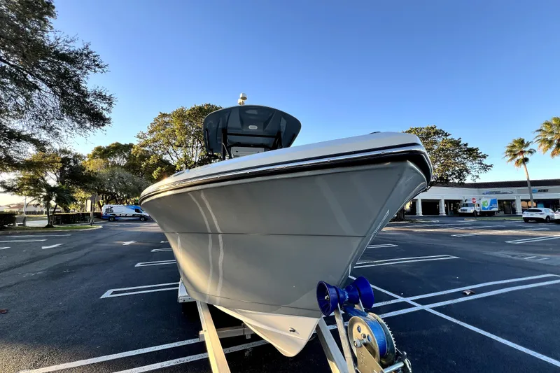 Slide: The Image of 2022 Cobia 220 Center Console boat on trailer in parking lot, sunny day. - 26