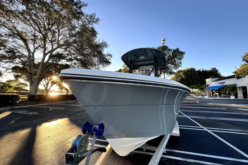 Slide: The Image of 2022 Cobia 220 Center Console boat on trailer in parking lot at sunset. - 27