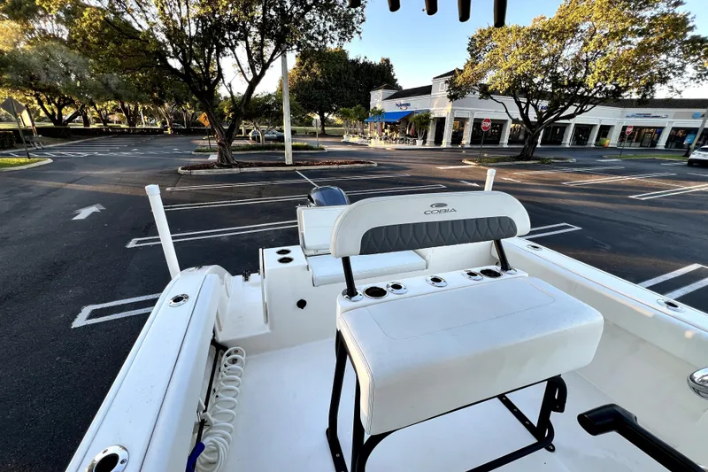Slide: The Image of 2022 Cobia 220 Center Console boat in parking lot, surrounded by trees and shops. - 31
