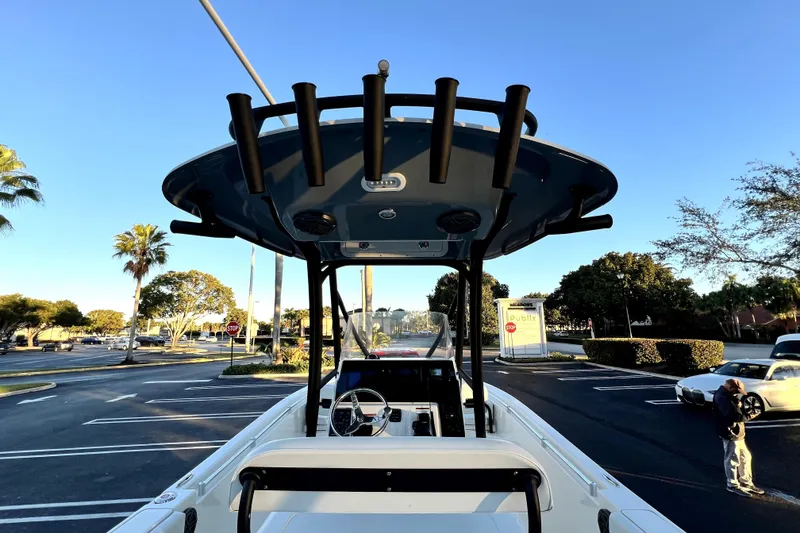 Slide: The Image of 2022 Cobia 220 Center Console boat in parking lot, sunny day, palm trees visible. - 36