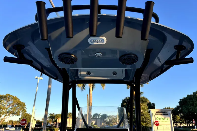 Slide: The Image of 2022 Cobia 220 Center Console boat with T-top and rod holders, sunny day. - 38