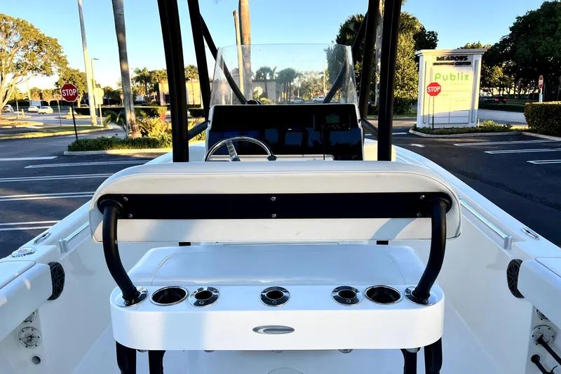 Slide: The Image of 2022 Cobia 220 Center Console boat interior with seating and cup holders in a parking lot. - 39