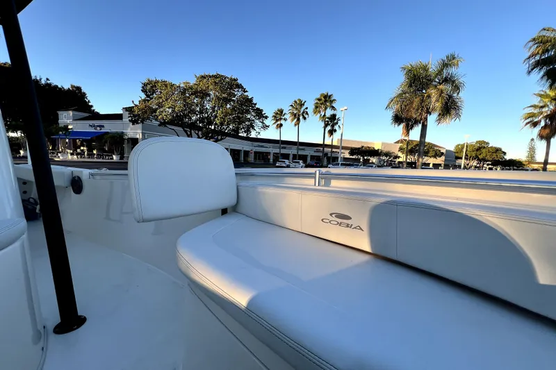 Slide: The Image of 2022 Cobia 220 Center Console boat interior with palm trees and buildings in the background. - 41