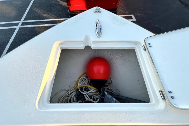 Slide: The Image of Open storage compartment on 2022 Cobia 220 Center Console with ropes and red buoy. - 44