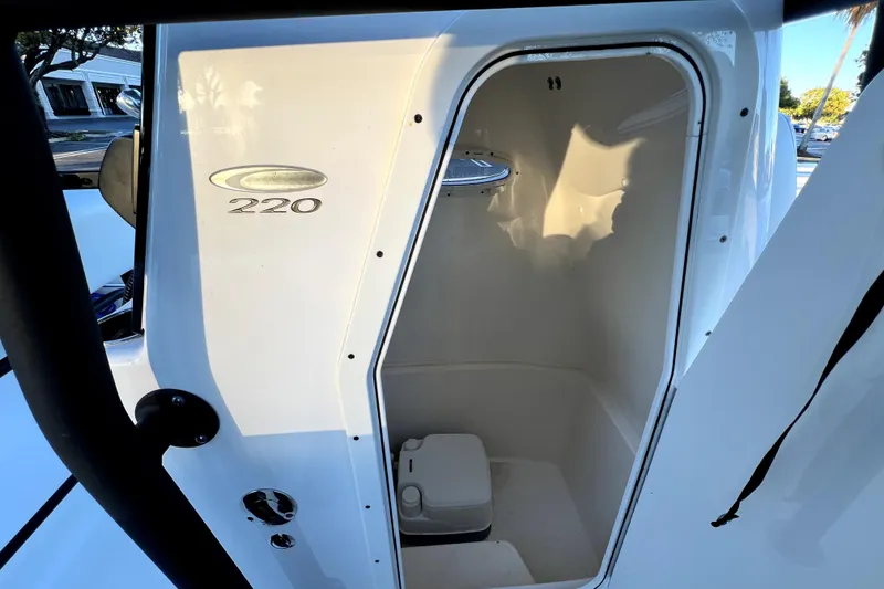 Slide: The Image of 2022 Cobia 220 Center Console boat interior with compact toilet. - 46