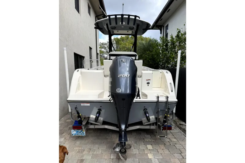 Slide: The Image of 2022 Cobia 220 Center Console with Yamaha outboard motor in a parking lot. - 5