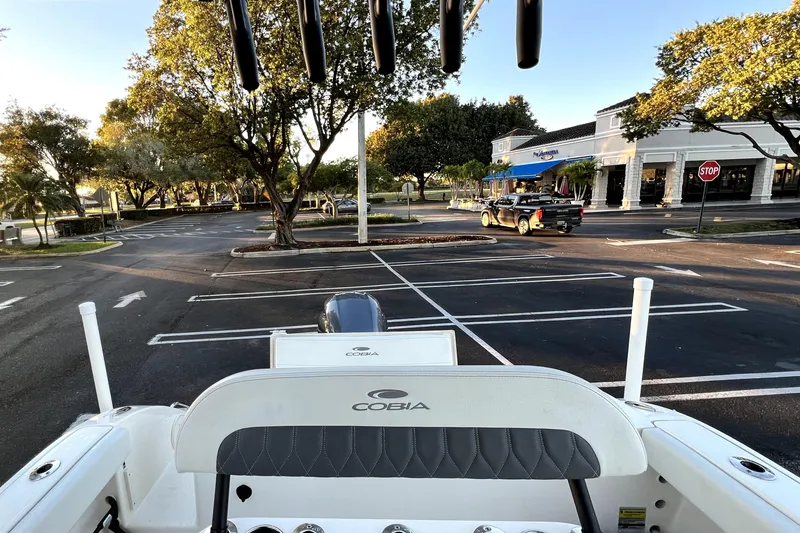 Slide: The Image of 2022 Cobia 220 Center Console boat parked in an empty lot with trees and buildings. - 50