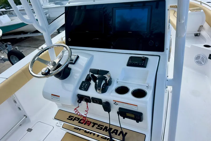 Slide: The Image of 2021 Sportsman Open 282 Center Console boat dashboard with steering wheel and electronic controls. - 18