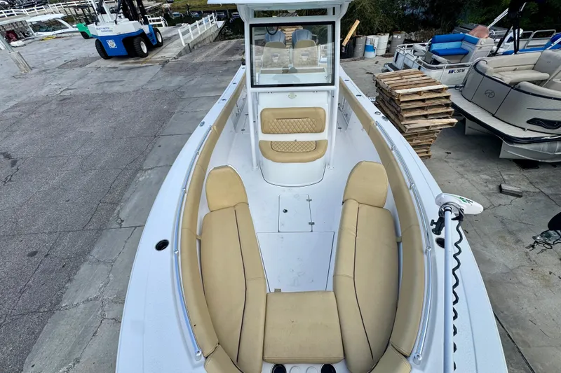 Slide: The Image of 2021 Sportsman Open 282 Center Console boat with beige seating, docked at marina. - 26