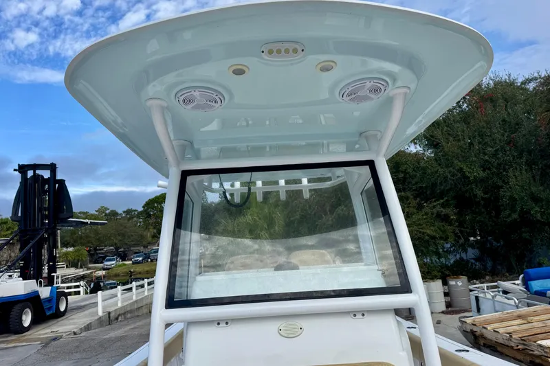 Slide: The Image of 2021 Sportsman Open 282 Center Console boat with T-top and windshield, docked outdoors. - 30