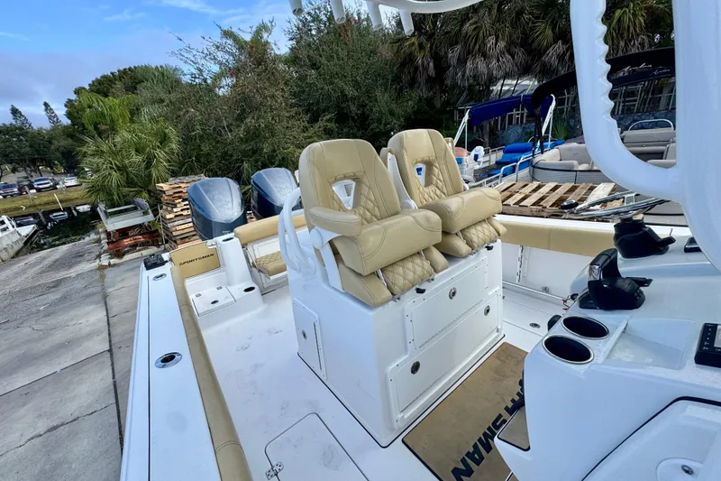 Slide: The Image of 2021 Sportsman Open 282 Center Console boat with beige seating and console, docked outdoors. - 34