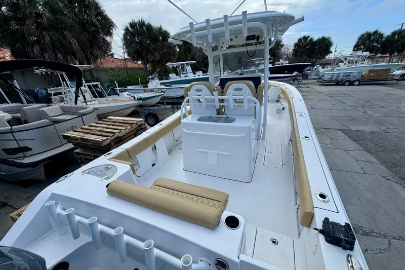 Slide: The Image of 2021 Sportsman Open 282 Center Console boat in marina, showcasing spacious deck and seating. - 8