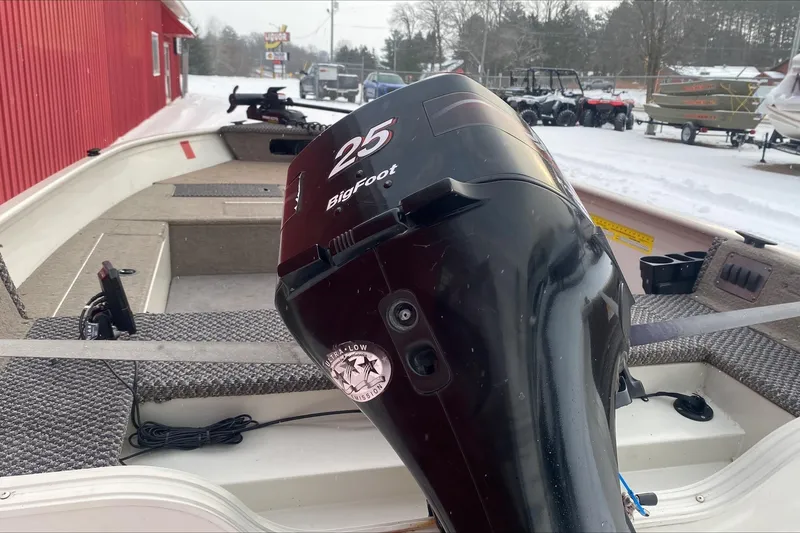 Slide: The Image of 2004 Crestliner Angler 1400 Tiller boat with 25 BigFoot motor in snowy setting. - 3
