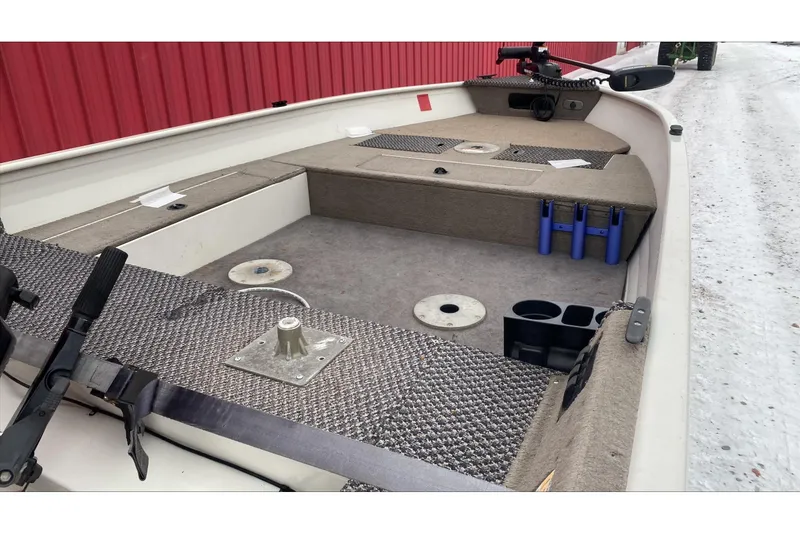 Slide: The Image of 2004 Crestliner Angler 1400 Tiller boat interior with carpeted deck and storage compartments. - 4