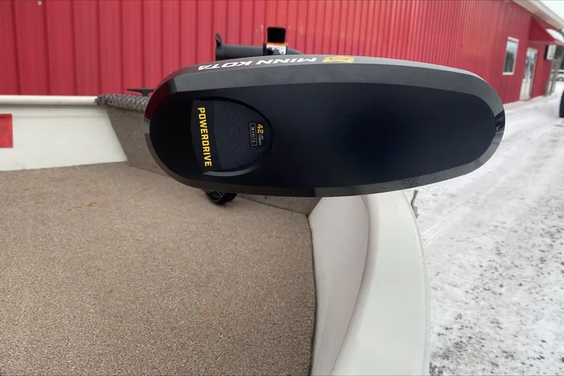 Slide: The Image of Minn Kota PowerDrive motor on 2004 Crestliner Angler 1400 Tiller boat, near red building. - 5