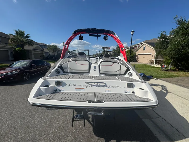 Slide: The Image of 2018 Yamaha Boats 212X on street, rear view, red accents, residential neighborhood. - 11