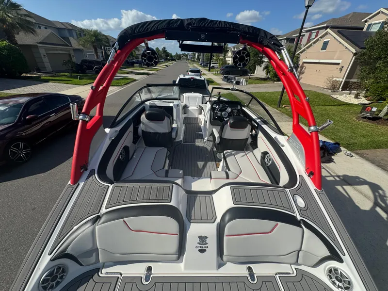 Slide: The Image of 2018 Yamaha Boats 212X with red accents, parked on a residential street. - 22