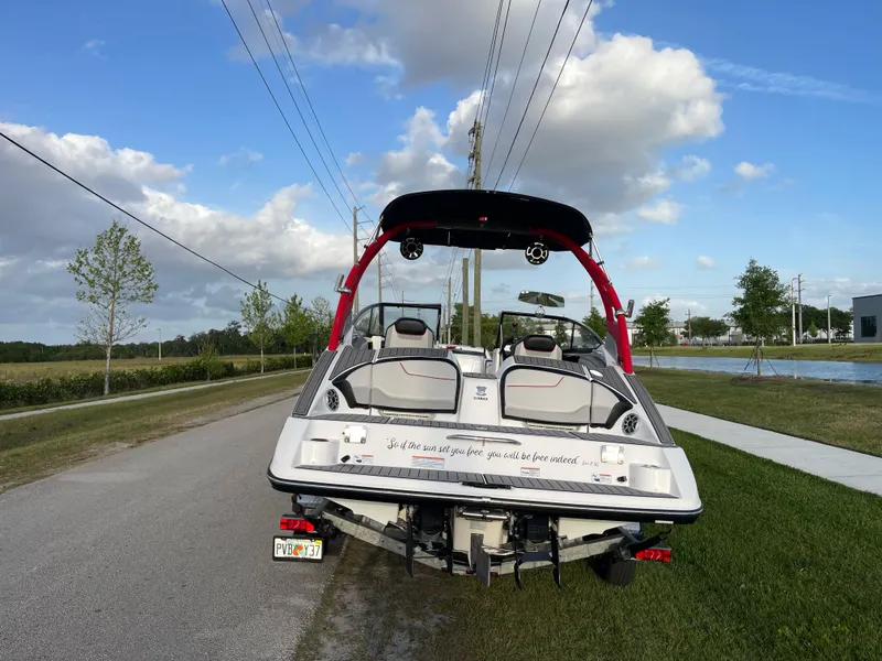 Slide: The Image of 2018 Yamaha Boats 212X on trailer, parked roadside under blue sky. - 3