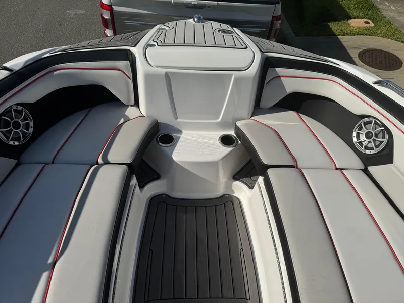 Slide: The Image of 2018 Yamaha Boats 212X interior with cushioned seating and cup holders. - 44