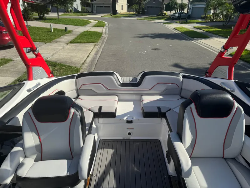 Slide: The Image of 2018 Yamaha Boats 212X interior with red accents, parked in a residential area. - 45