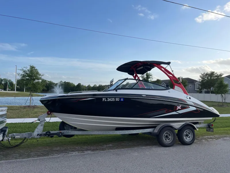 Slide: The Image of 2018 Yamaha Boats 212X on trailer by a lake, ready for adventure. - 5