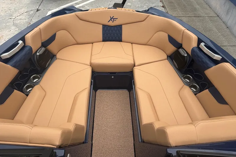 Slide: The Image of 2026 MasterCraft XT24 boat interior with tan seating and cup holders. - 10