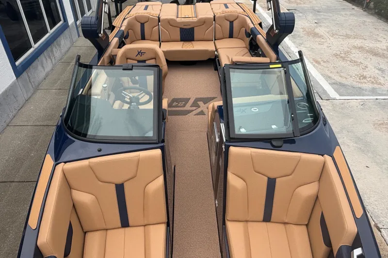 Slide: The Image of 2026 MasterCraft XT24 boat interior with tan and blue seating, viewed from above. - 11