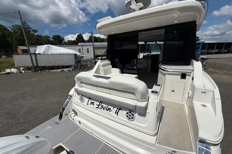 Slide: The Image of 2022 Regal 36 XO yacht with "I'm Lovin' It" text on the back, docked outdoors. - 15