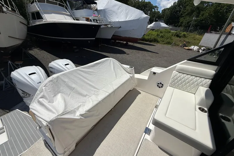 Slide: The Image of 2022 Regal 36 XO boat interior with covered seating and twin outboard engines. - 18