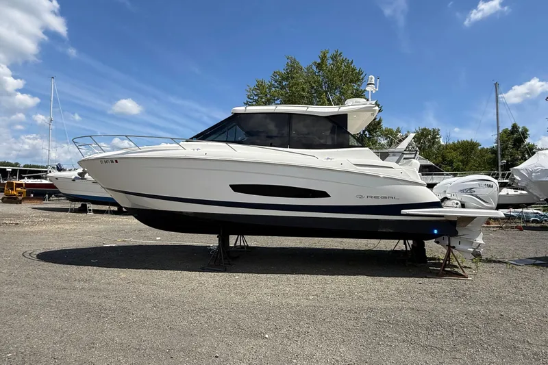 Slide: The Image of 2022 Regal 36 XO boat on dry dock under a clear blue sky. - 2