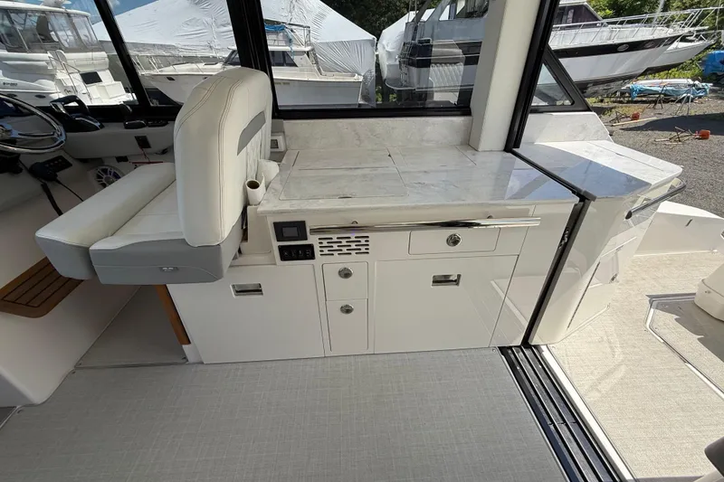 Slide: The Image of 2022 Regal 36 XO yacht interior with helm seat and kitchenette area. - 28