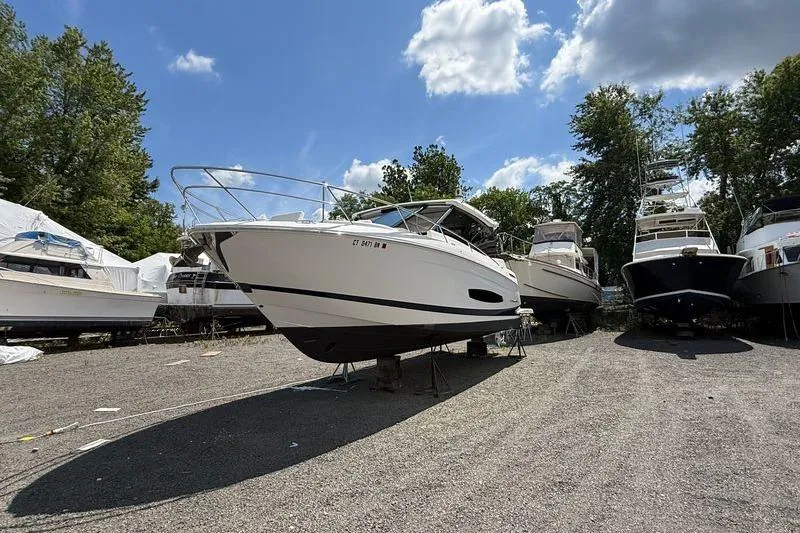 Slide: The Image of 2022 Regal 36 XO boat on dry dock, surrounded by other vessels, under a partly cloudy sky. - 3