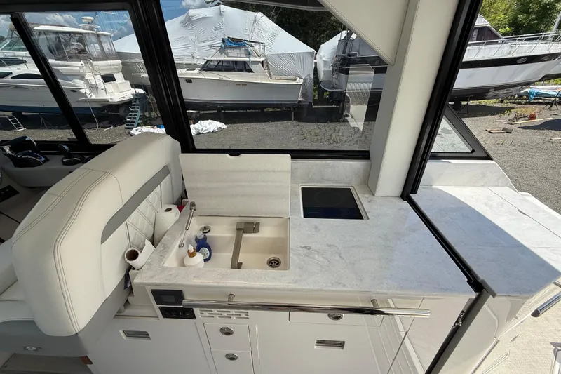 Slide: The Image of 2022 Regal 36 XO yacht interior with modern kitchenette and sleek design. - 30