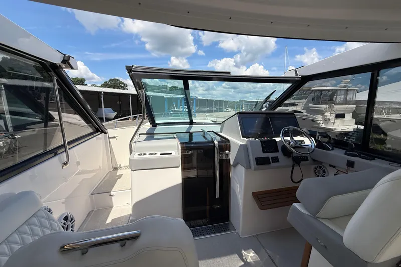 Slide: The Image of 2022 Regal 36 XO yacht cockpit with modern helm, luxurious seating, and clear skies. - 34