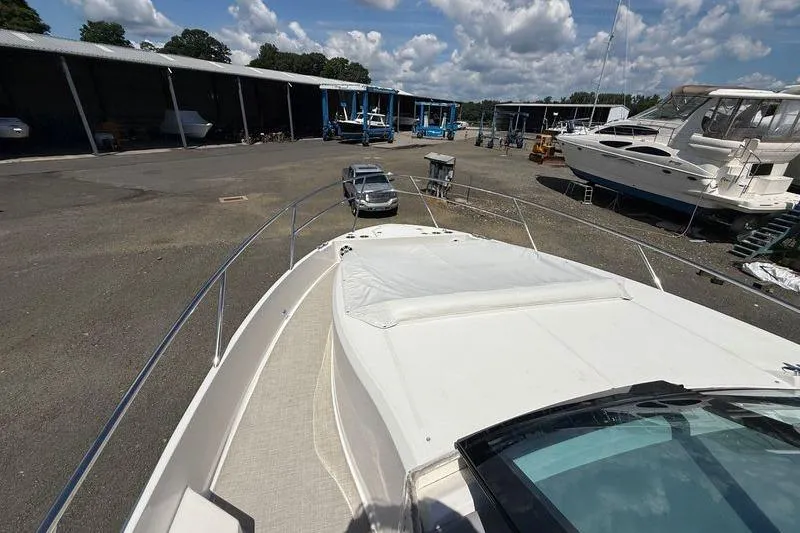 Slide: The Image of 2022 Regal 36 XO yacht in a marina with other boats and vehicles. - 43