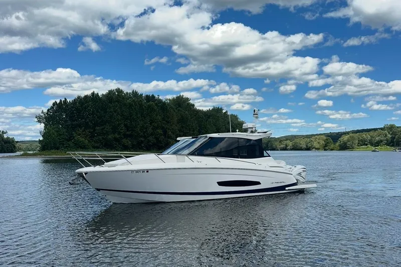 Slide: The Image of 2022 Regal 36 XO yacht cruising on a serene lake under a partly cloudy sky. - 60