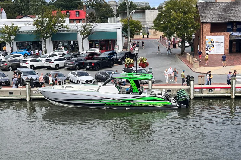 Slide: The Image of 2024 Deep Impact 399 Sport boat with vibrant green accents docked at a marina. - 10