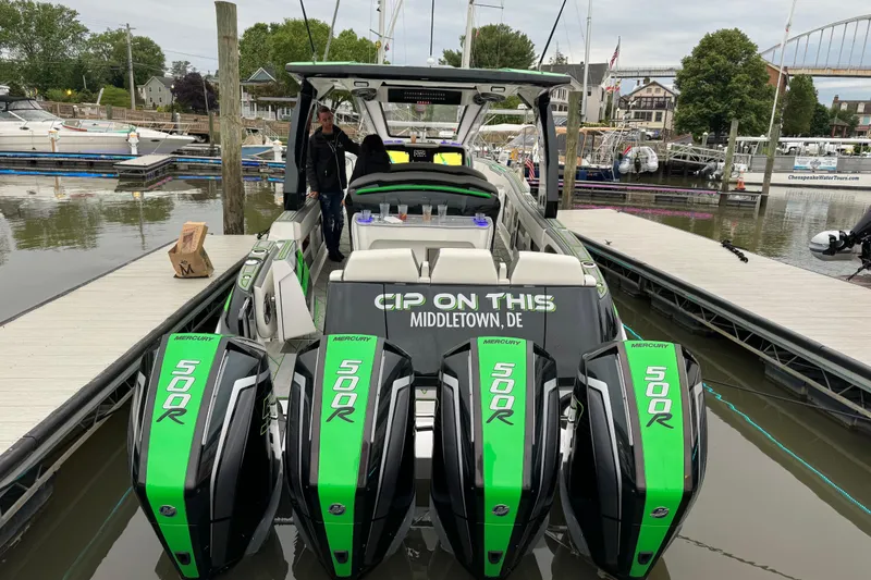 Slide: The Image of 2024 Deep Impact 399 Sport boat with four Mercury 500R engines docked at a marina. - 2